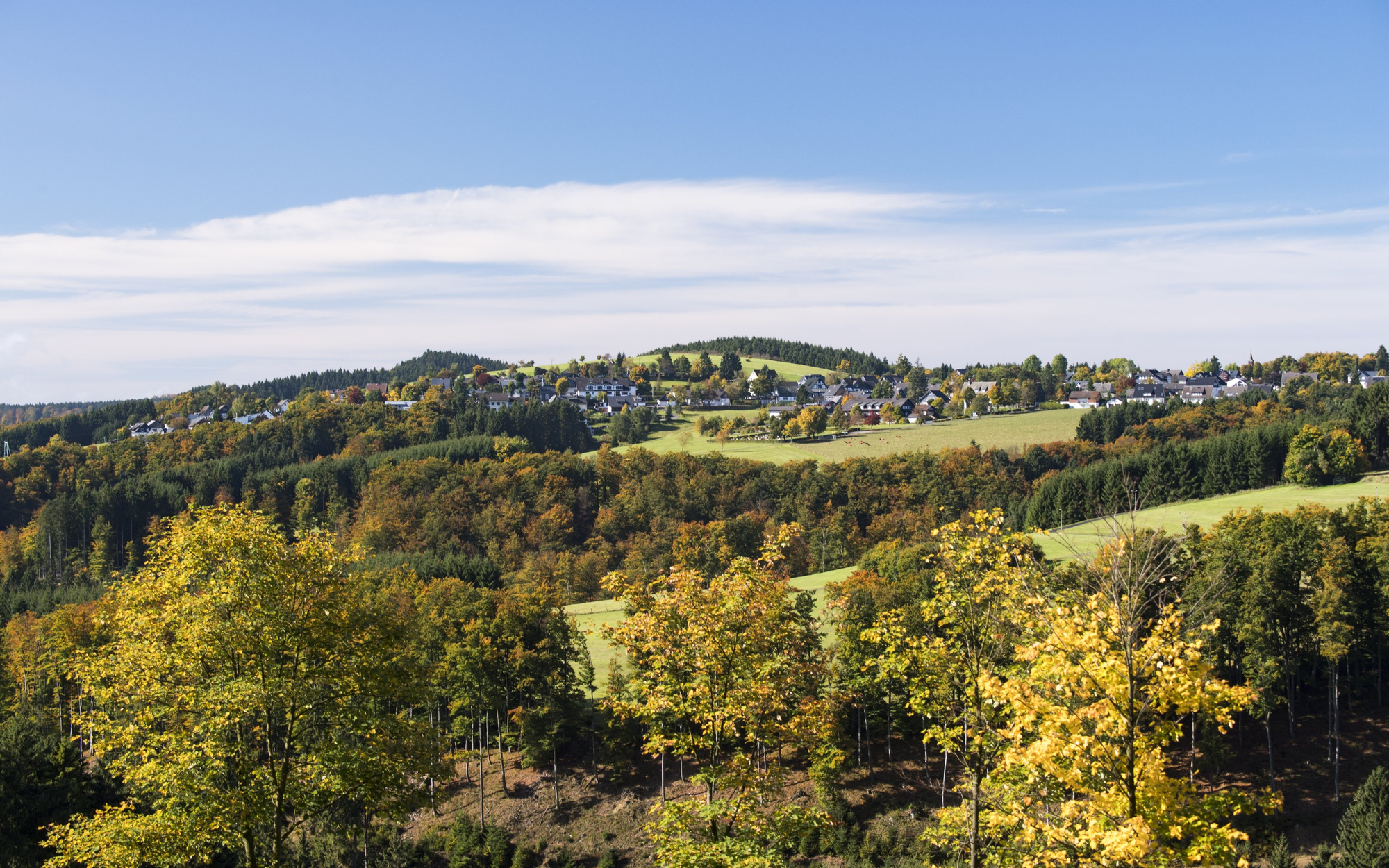Die Ortschaft Langewiese inmitten von Wiesen, Wäldern und Bergen.
