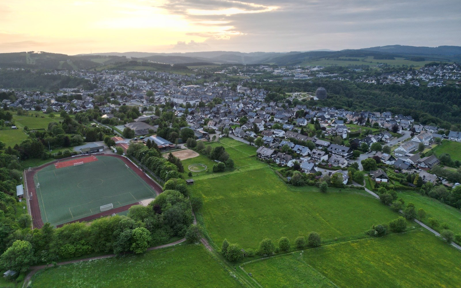 Winterberg_Sportplatz_Abend_Sonnenuntergang_Sommer Drohnenaufnahme vom Sportplatz und einem Teil der Stadt Winterberg.