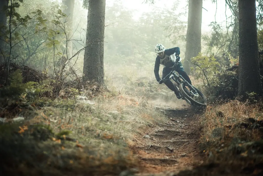 Ein Mann fährt mit seinem Mountainbike auf einem Trail des Trailparks durch eine scharfe Kurve