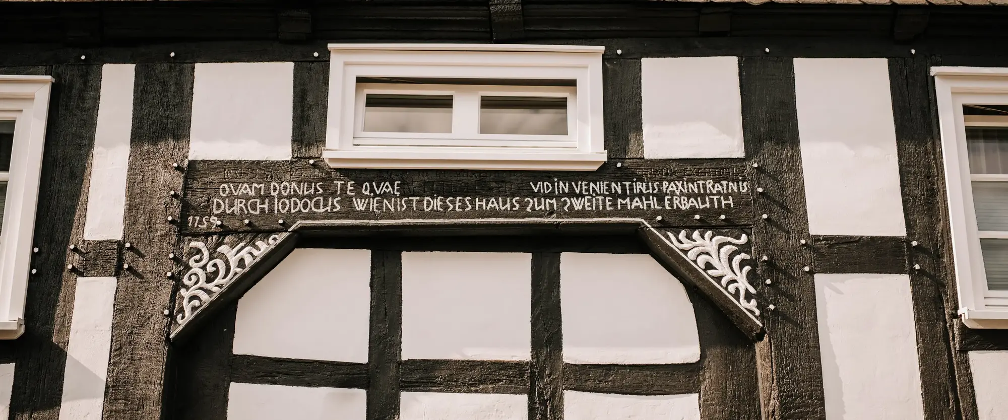Die Fassade eines Fachwerkhauses mit typischer Inschrift in der Altstadt Winterbergs.