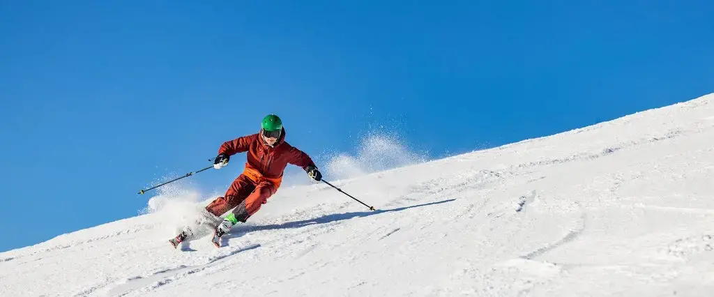 Skifahrer fährt bei Sonnenschein eine Piste im Skiliftkarussell Winterberg hinunter.