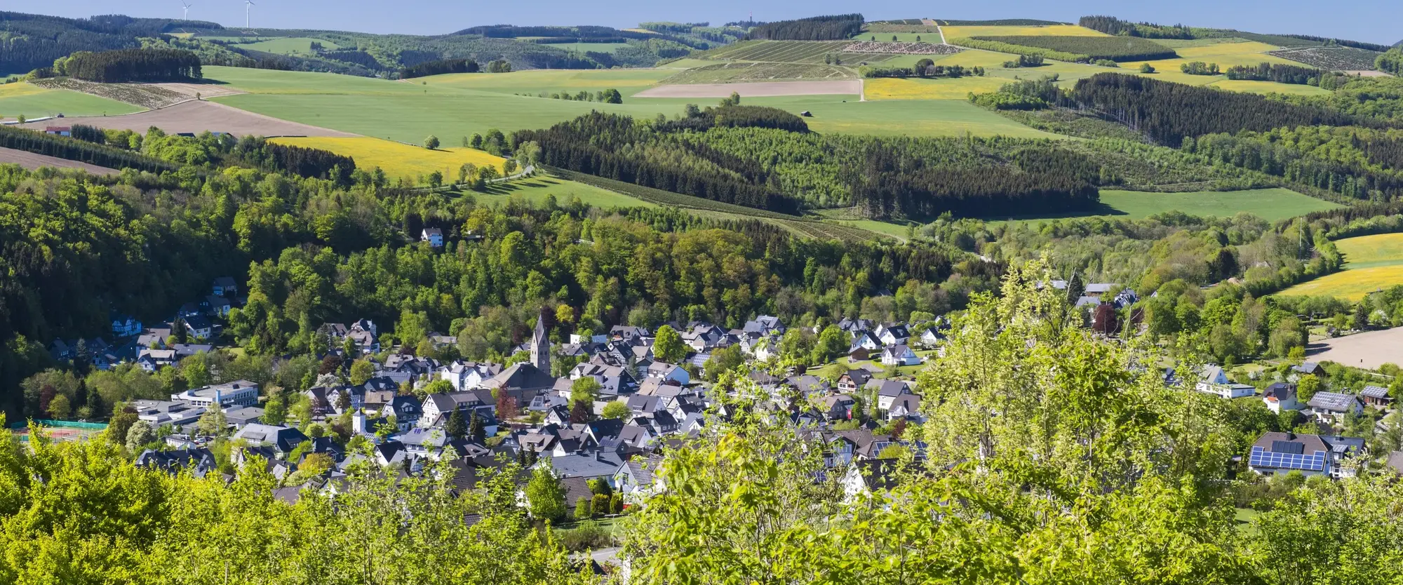Die Ortschaft Siedlinghausen in mitten von Bergen, Wiesen und Wäldern.
