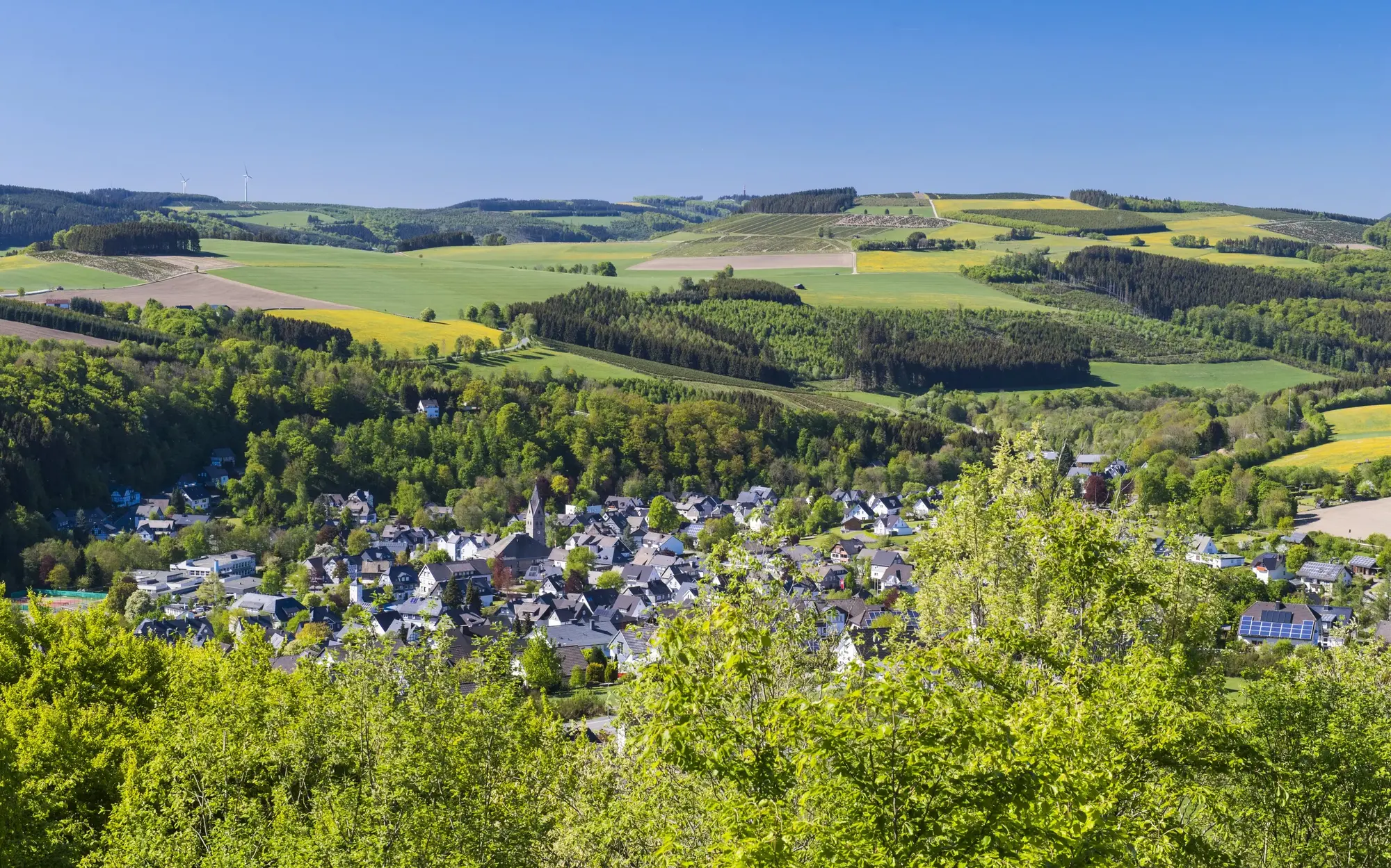 Die Ortschaft Siedlinghausen in mitten von Bergen, Wiesen und Wäldern.