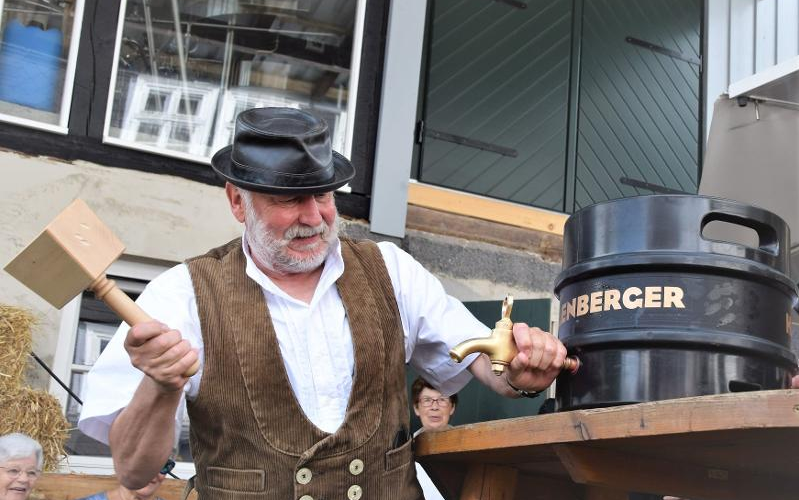 Ein Mann ist dabei ein Fass Bier anzustechen.