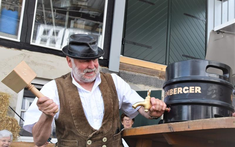 Ein Mann ist dabei ein Fass Bier anzustechen.