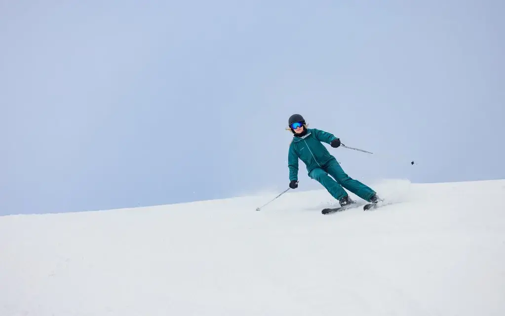 Ein Skifahrer fährt auf seinen Skiern einen Hang hinunter.