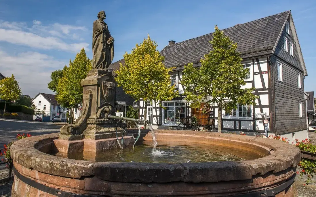 Ein Brunnen mit einer Figur in der Altstadt von Hallenberg.