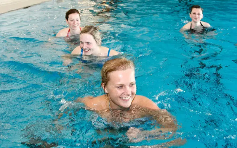 Vier Frauen schwimmen im Schwimmbecken.