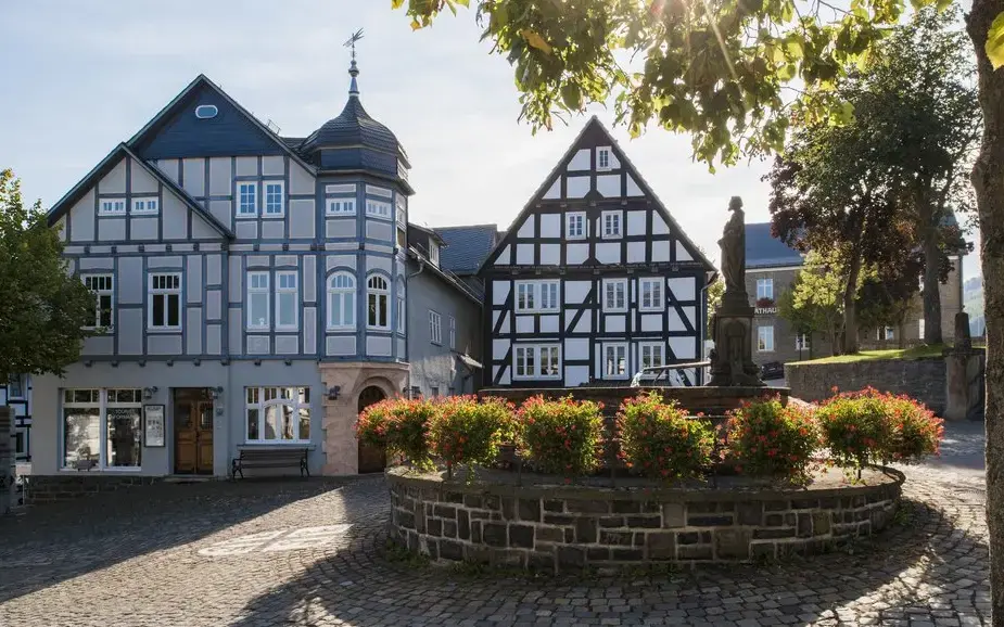 Altstadt von Hallenberg mit Fachwerkhäusern und Brunnen im Sonnenschein