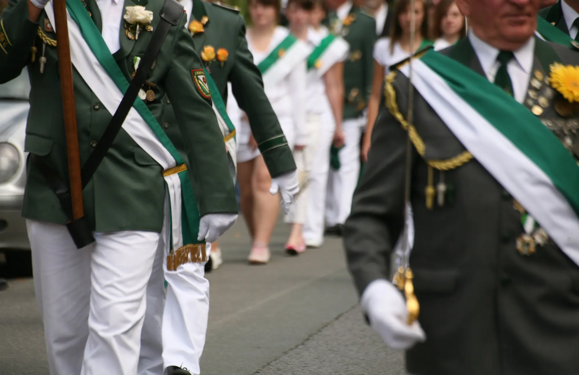 Mehrere Personen in Uniform, die marschieren.