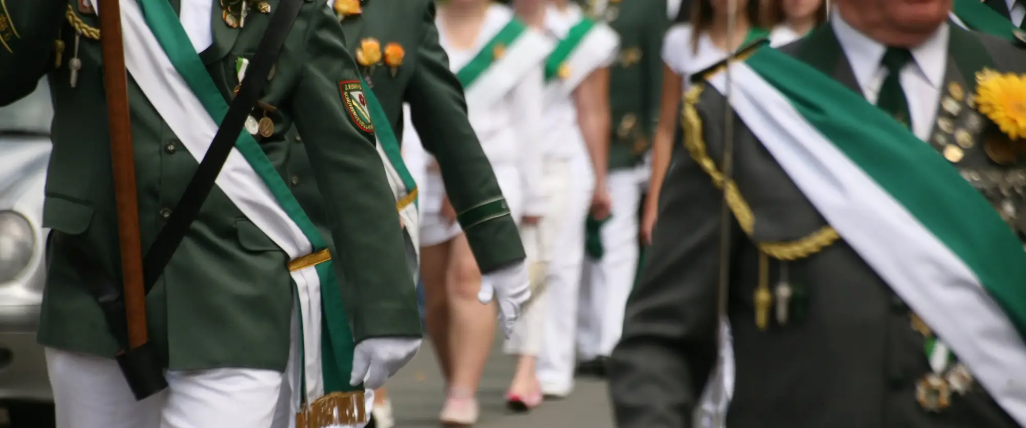 Mehrere Personen in Uniform, die marschieren.