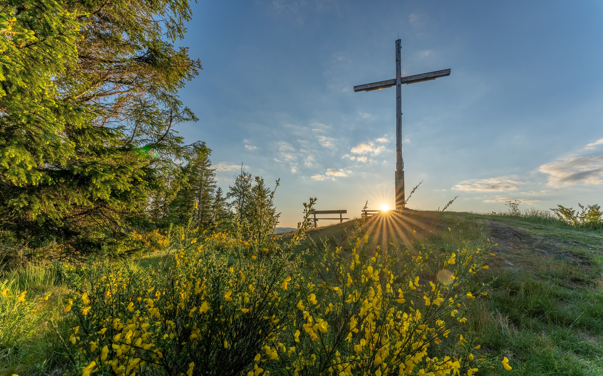 Das Kreuz auf dem Alten Grimmen mit aufgehender Sonne im Hintergrund.