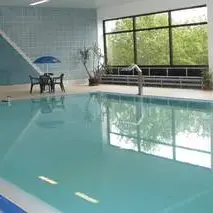 Das Schwimmbecken im Hallenbad Hallenberg mit Sitzgelegenheiten.