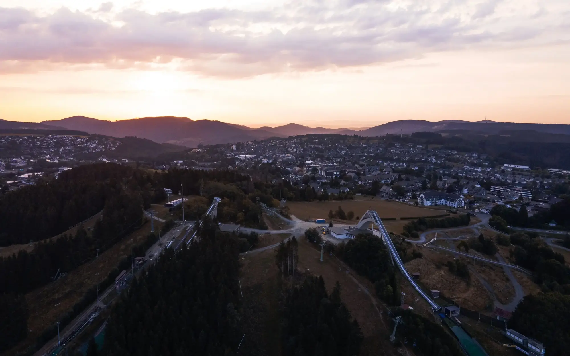 Die St. Georg Sprungschanze und ein Teil der Stadt Winterberg in der Abenddämmerung.