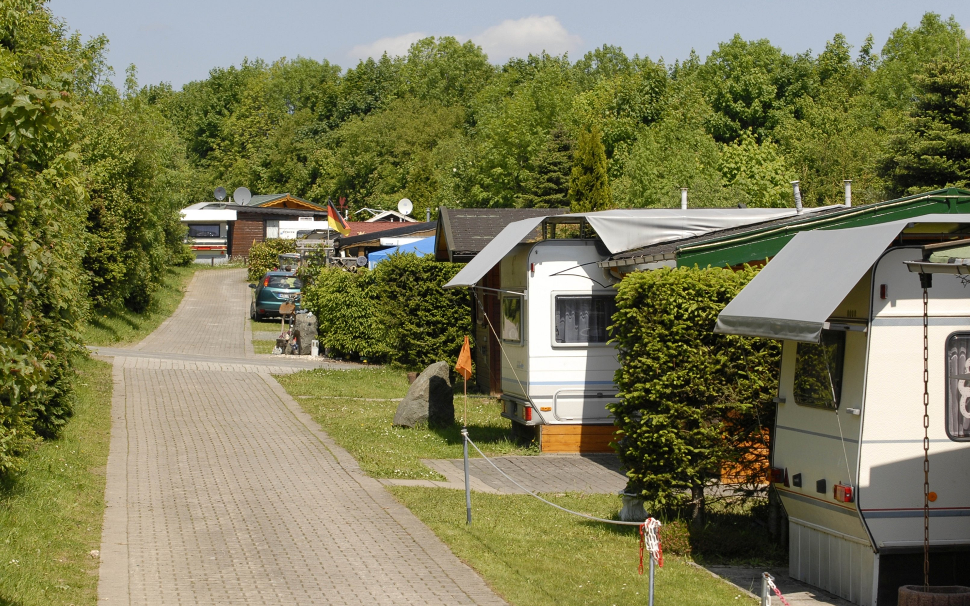 Weg auf dem Campingplatz mit einigen Stellplätzen und Wohnmobilen.