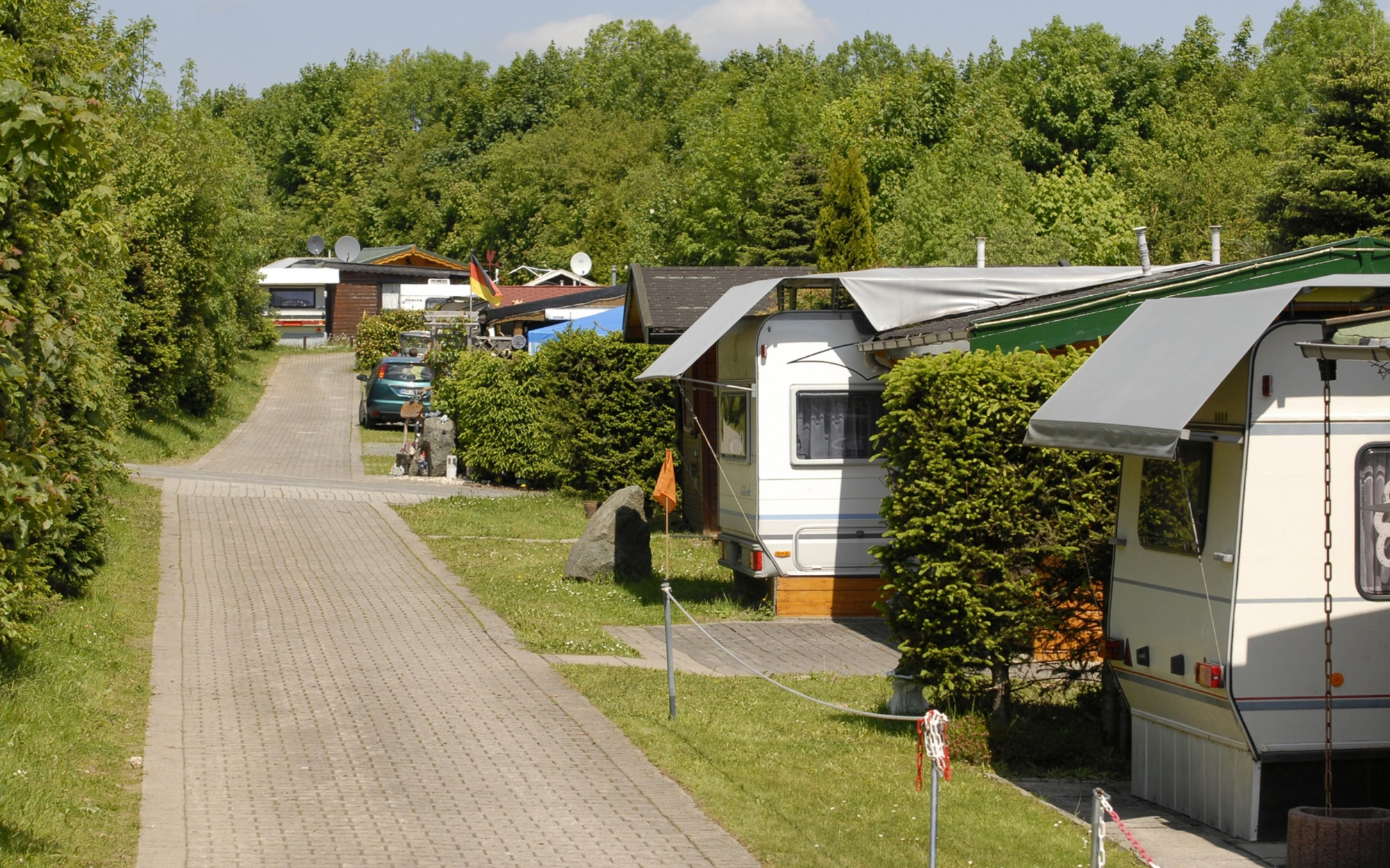 Weg auf dem Campingplatz mit einigen Stellplätzen und Wohnmobilen.