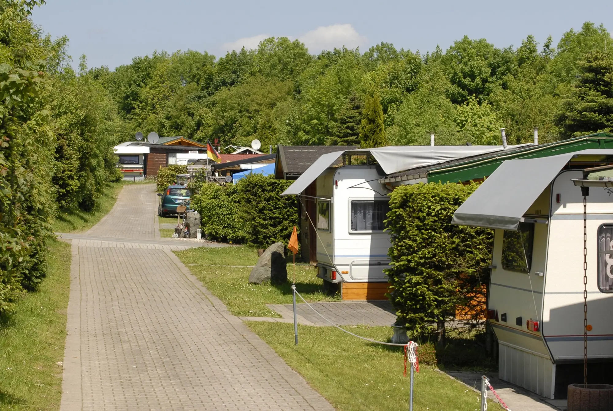 Weg auf dem Campingplatz mit einigen Stellplätzen und Wohnmobilen.